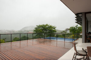 Deck de madeira ao redor de piscina residencial, destacando o acabamento natural e o conforto térmico do ambiente.