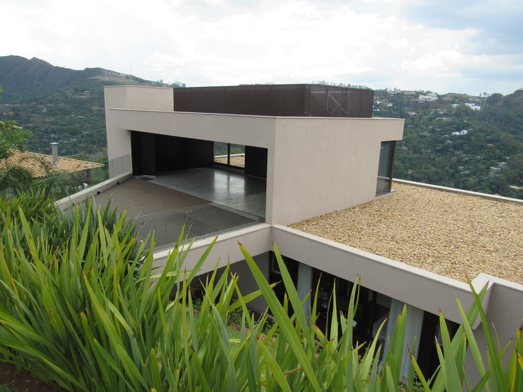 Fachada frontal da casa em terreno inclinado no condomínio Vila Alpina, Belo Horizonte
