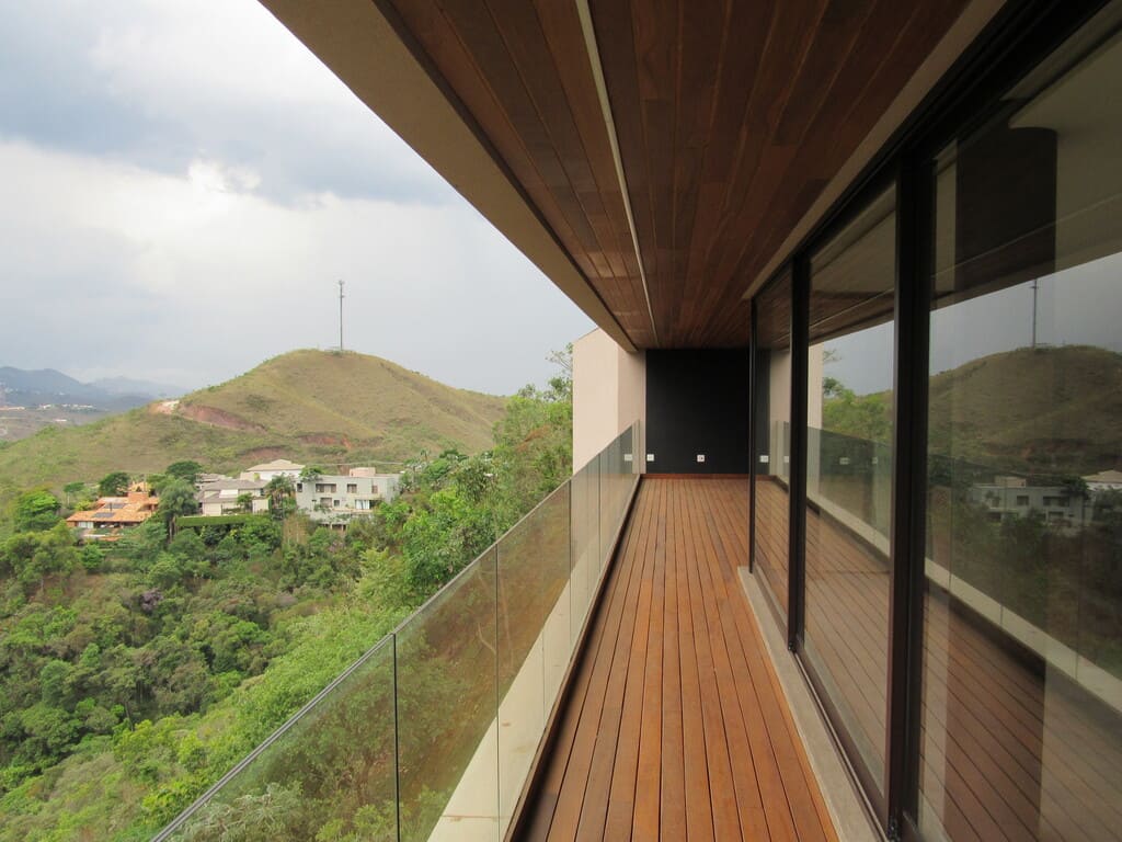 Forro e piso de madeira na varanda da casa no condomínio Vila Alpina, Belo Horizonte, construída pela Mazí Construtora.