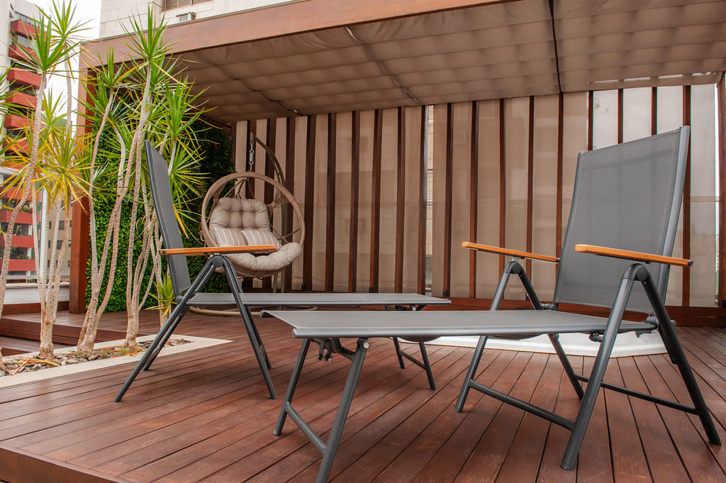 Cadeira de jardim moderna na área externa do apartamento reformado na Savassi, Belo Horizonte, projeto realizado pela Mazí Construtora.