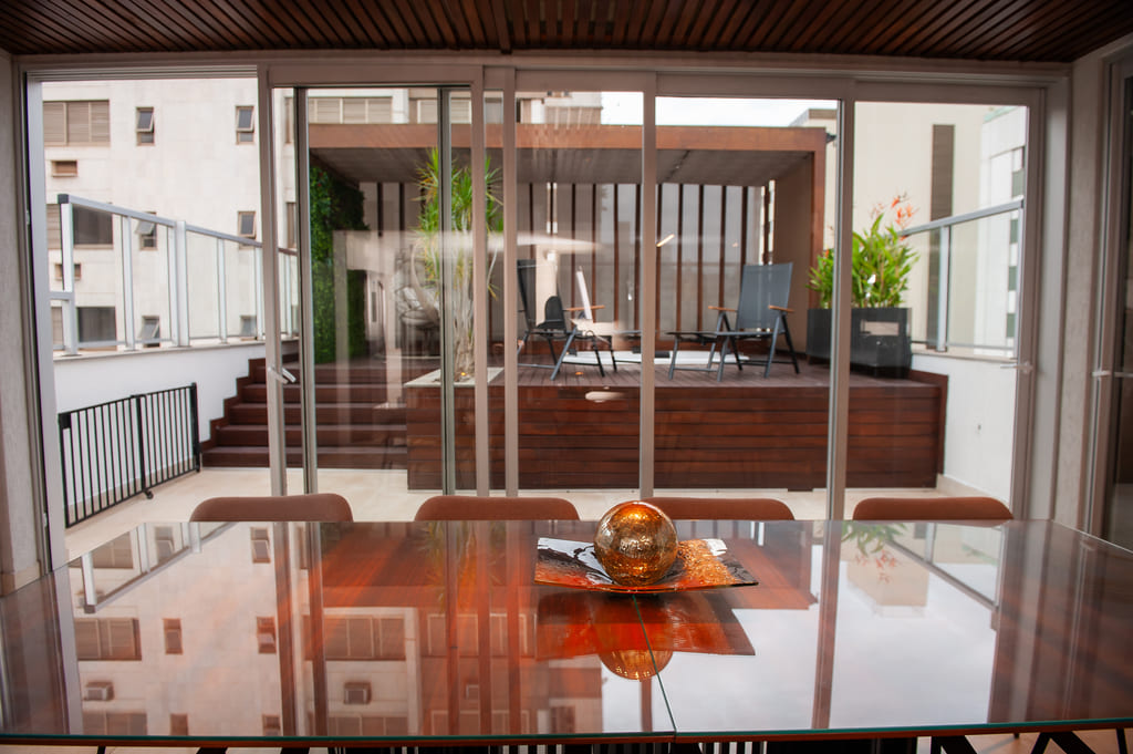 Mesa de jantar moderna na sala integrada do apartamento reformado na Savassi, Belo Horizonte, projeto realizado pela Mazí Construtora.