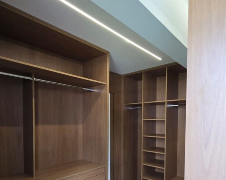 Iluminação linear embutida em teto de apartamento com design minimalista.