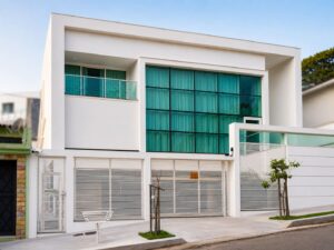 Fachada de casa moderna com grandes janelas de vidro e varanda